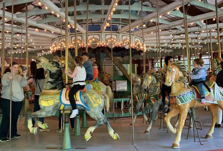 Lower school students riding on a carousel